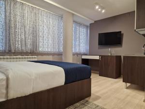 ベオグラードにあるCenter Prestige Apartmentsのベッドと薄型テレビのある寝室