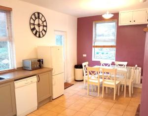 a kitchen and dining room with a table and a refrigerator at Beach House, Llanddulas near Colwyn Bay in Llanddulas