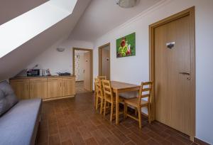 - une cuisine et une salle à manger avec une table et des chaises dans l'établissement Dobosi Pincészet, à Szentantalfa
