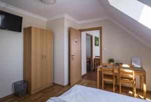 - une chambre avec un lit, une table et un bureau dans l'établissement Dobosi Pincészet, à Szentantalfa