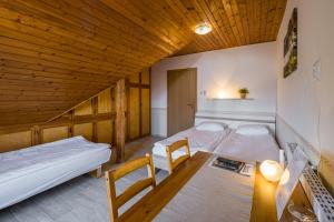 - 2 lits dans une chambre avec une table et des chaises dans l'établissement Dobosi Pincészet, à Szentantalfa