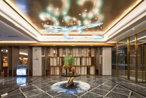 een lobby met een bibliotheek met een vogel op het plafond bij Howard Johnson Paragon Hotel Beijing Central in Beijing