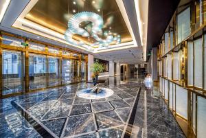 eine Lobby mit einem Brunnen in der Mitte eines Gebäudes in der Unterkunft Howard Johnson Paragon Hotel Beijing Central in Peking