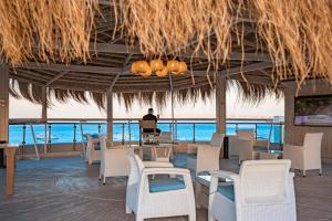 a man sitting on a laptop in a restaurant overlooking the ocean at Redcon Suites in Hurghada