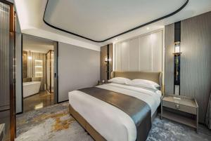 a bedroom with a large bed and a bathroom at Howard Johnson Paragon Hotel Beijing Central in Beijing