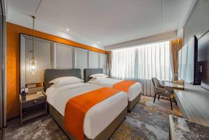 北京市にあるHoward Johnson Paragon Hotel Beijing Centralのベッド2台とデスクが備わるホテルルームです。