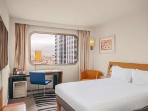 una camera d'albergo con letto e finestra di Novotel Paris Centre Tour Eiffel a Parigi