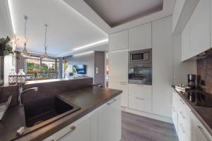a kitchen with white cabinets and a sink at La Bagatelle by Baltica Apartments + parking in Sopot