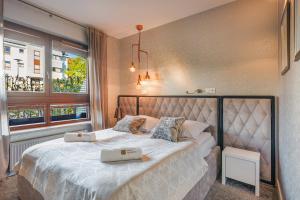 a bedroom with a large bed with two bags on it at La Bagatelle by Baltica Apartments + parking in Sopot