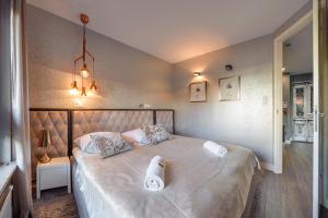 a bedroom with a bed with two white towels on it at La Bagatelle by Baltica Apartments + parking in Sopot
