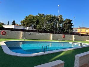 a swimming pool in a yard with green grass at Estrella I in Vinarós