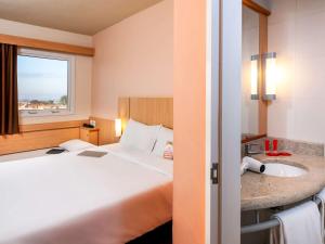 ein Hotelzimmer mit einem Bett und einem Waschbecken in der Unterkunft ibis Ourinhos in Ourinhos