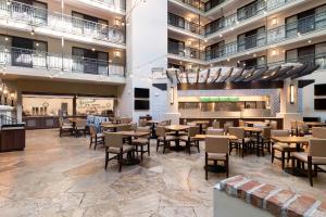 a restaurant with tables and chairs in a building at Embassy Suites by Hilton Los Angeles International Airport South in El Segundo