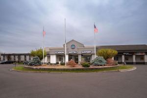 a building with two flags in a parking lot at Clarion Hotel Detroit Metro Airport in Romulus