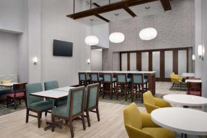 奥兰治堡Hampton Inn & Suites Orangeburg, SC的配有桌椅和电视的餐厅 更多37张照片