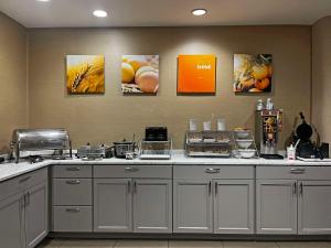 a kitchen counter with pictures on the wall at Comfort Suites Peoria Sports Complex in Peoria