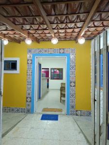 a room with a yellow wall and a blue doorway at Pousada das Ostras in Anchieta