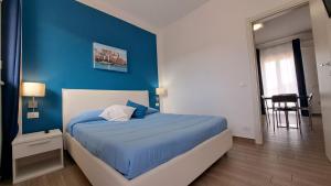 a blue bedroom with a bed with a blue wall at Le Due Sicilie B&B in Lascari