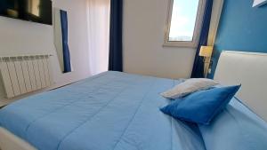 1 cama azul con 2 almohadas azules en una habitación en Le Due Sicilie B&B, en Lascari