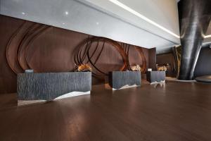 een kamer met 2 tafels en een bruine muur bij Hilton Porto Gaia in Vila Nova de Gaia