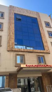 a tall building with blue glass windows on it at راحة ترف Chicnest in Jeddah +14 photos