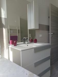 a white kitchen with a sink and a mirror at EDEN. La casa di Claudia in Ronciglione