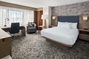 una camera d'albergo con un grande letto e una scrivania di DoubleTree by Hilton Poughkeepsie a Poughkeepsie