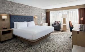 una habitación de hotel con una cama grande y una silla en DoubleTree by Hilton Poughkeepsie, en Poughkeepsie