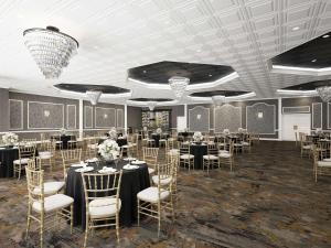 un salón de banquetes con mesas, sillas y lámparas de araña en DoubleTree by Hilton Poughkeepsie, en Poughkeepsie