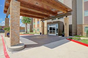a building with a large glass door in a courtyard at Country Inn & Suites by Radisson Houston Westchase-Westheimer in Houston
