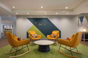 a waiting room with yellow chairs and a table at Spark By Hilton Germantown Washington Dc North in Germantown