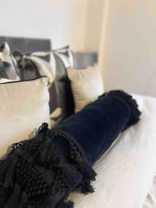 um vestido preto sentado numa cama com almofadas em Streatham Studio em Londres