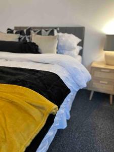 um quarto com uma cama com um cobertor amarelo em Streatham Studio em Londres