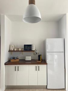 a kitchen with white cabinets and a white refrigerator at Meraki in Playa Blanca