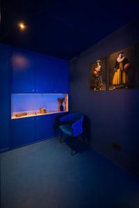 a blue kitchen with blue cabinets and a blue chair at Fontana 16 Rooms in Milan