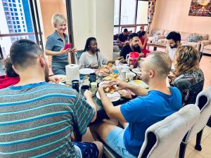 Eine Gruppe von Menschen, die an einem Tisch sitzen und Essen essen. in der Unterkunft Marina Homes in Dubai