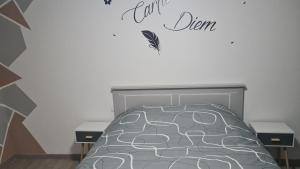 1 dormitorio con 1 cama con un cartel en la pared en Aux P'tits Cabris, en Lahayville
