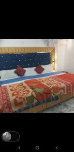 a bedroom with a large bed with red pillows at Hotel Shehnaz Inn - Walking Distance for Golden Temple in Amritsar
