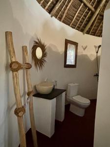 ein Bad mit einem Waschbecken und einem WC in der Unterkunft Dreamland Bungalows Michamvi Kae in Michamvi