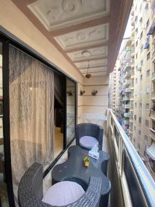 ein Balkon mit einem Tisch und Stühlen auf einem Balkon in der Unterkunft Corniche Glimpse in Alexandria