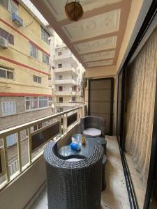 Apartment mit Balkon, Tisch und Fenster in der Unterkunft Corniche Glimpse in Alexandria