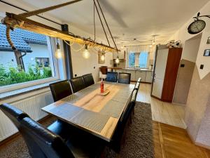 a dining room with a table and a refrigerator at Domek Monte Black z jacuzzi i sauną fińską in Stronie Śląskie