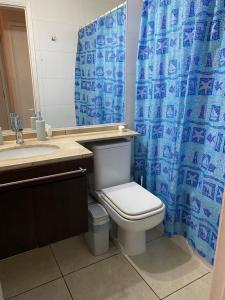 ein Bad mit einem WC und einem blauen Duschvorhang in der Unterkunft Hermoso y cómodo departamento en el centro de Viña del Mar - Viña Park 2 in Viña del Mar