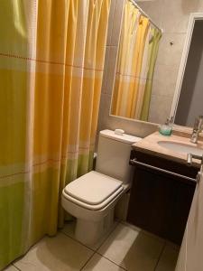 a bathroom with a yellow shower curtain and a toilet at Hermoso y cómodo departamento en el centro de Viña del Mar - Viña Park 2 in Viña del Mar