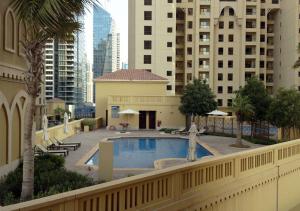 a swimming pool in a city with tall buildings at 1min walk studio in front of JBR beach in Dubai