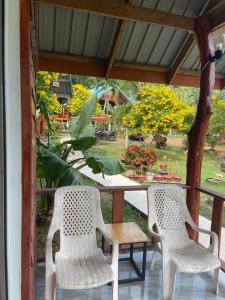 2 sillas blancas y una mesa en un porche en Happy Home Kohjum, en Ko Jum