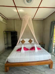 a bedroom with a white bed with a canopy at Happy Home Kohjum in Ko Jum