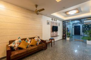 uma sala de estar com um sofá e uma televisão em Plum Tree Hotels em Gurgaon
