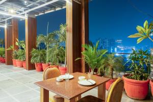 um restaurante com mesa e cadeiras e vasos de plantas em Plum Tree Hotels em Gurgaon