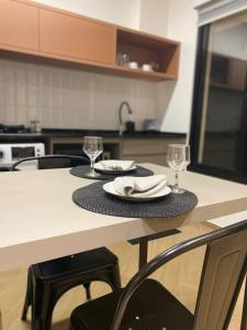 una cucina con tavolo con due piatti e bicchieri da vino di NOVO LOFT inteiro New York, próx. Shop Garten a Joinville